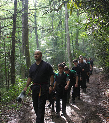 Group of Elevo Dynamics students being led along a path in the woods